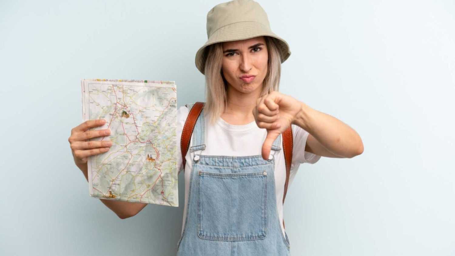 Woman with road map showing thumbs down