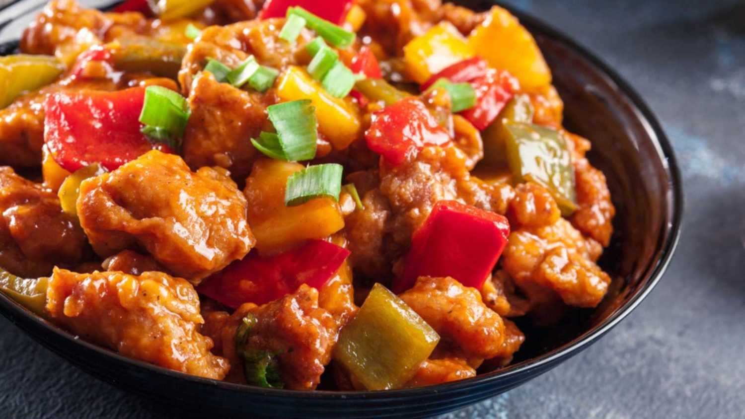 Sweet and sour chicken with colorful bell pepper on a plate. Chinese dish