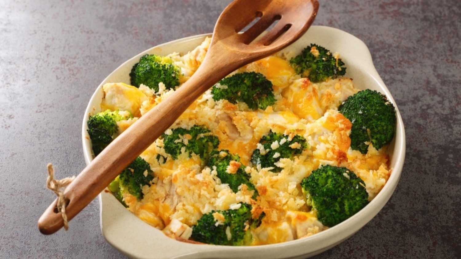 Broccoli Chicken divan is a creamy casserole topped with crispy buttered breadcrumbs close up in the dish on the old table. Horizontal