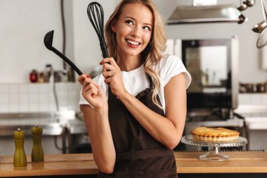 Woman wearing apron having kitchen tools