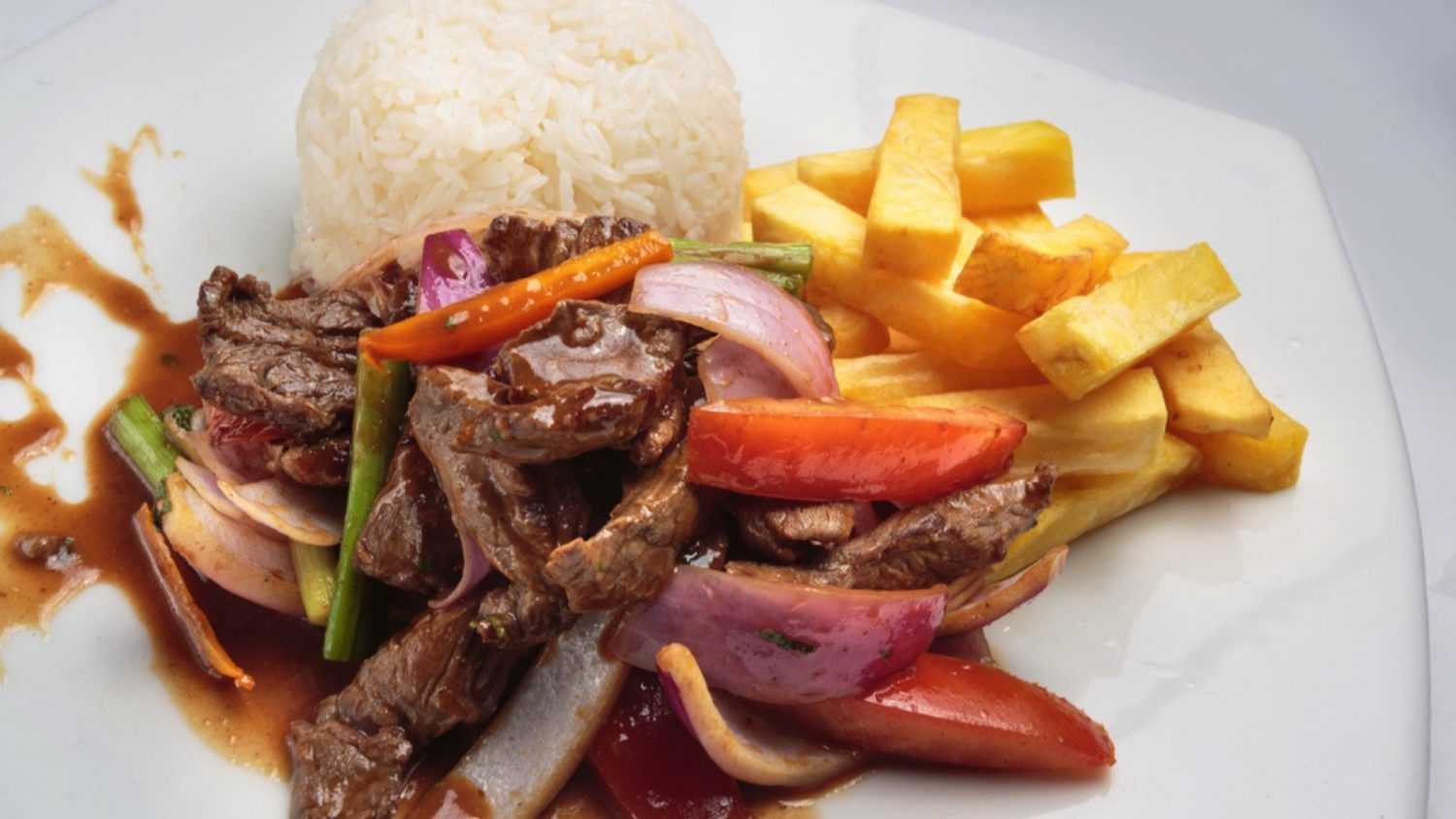 Peruvian food "lomo saltado":A salted beef with tomatoes, onion, fried potatoes and rice.