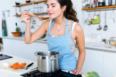 Woman cooking smelling aroma
