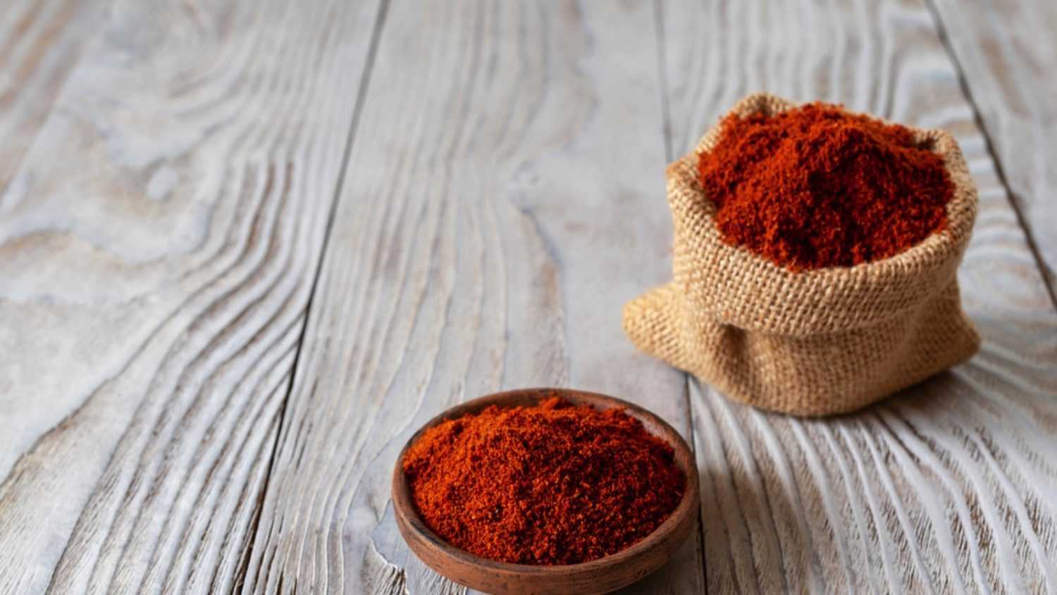 Berbere is the main part in the cuisines of Ethiopia and Eritrea. A mixture of spices, usually including red pepper, ginger, cloves, coriander, allspice. Wooden background.