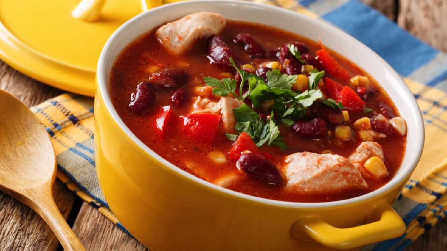 Spicy chicken with chili, red beans, corn and tomatoes close-up in a bowl on the table. horizontal