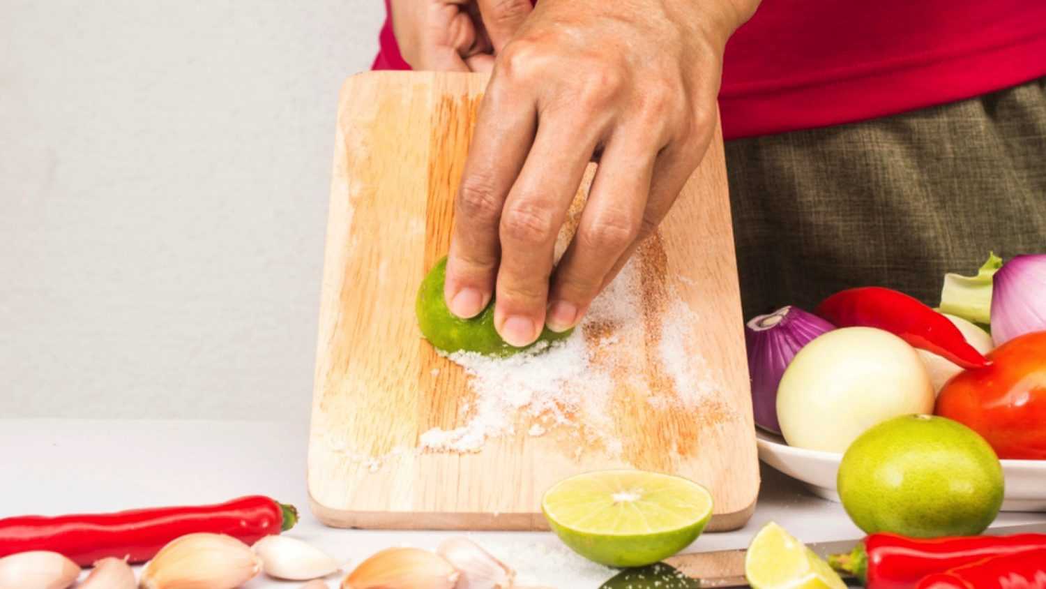 Cleaning choping board with lemon and salt