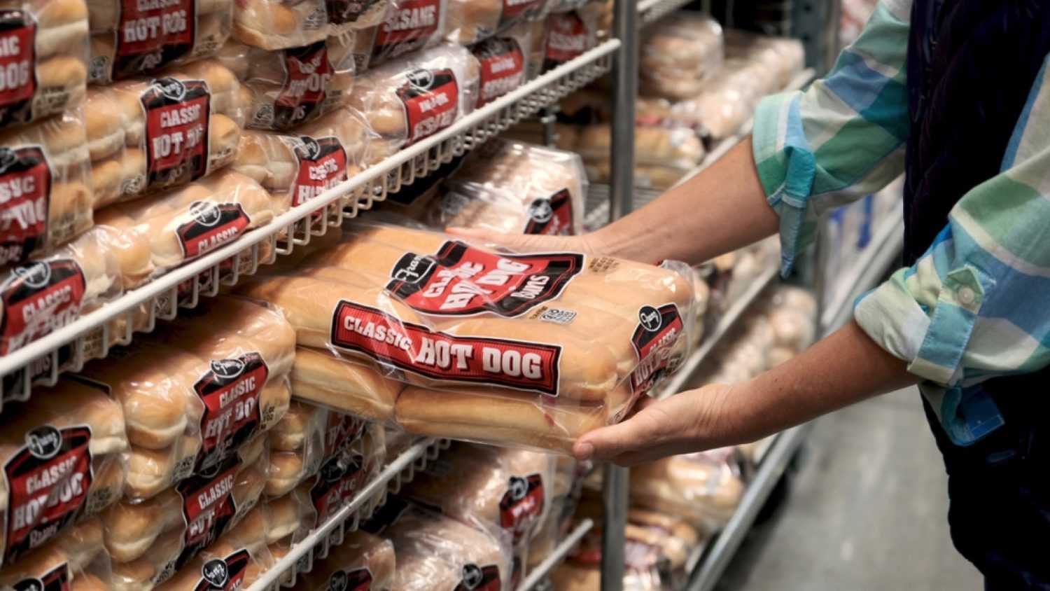 Woman buying Hotdog Buns at supermarket
