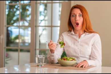 Woman eating salad shocked