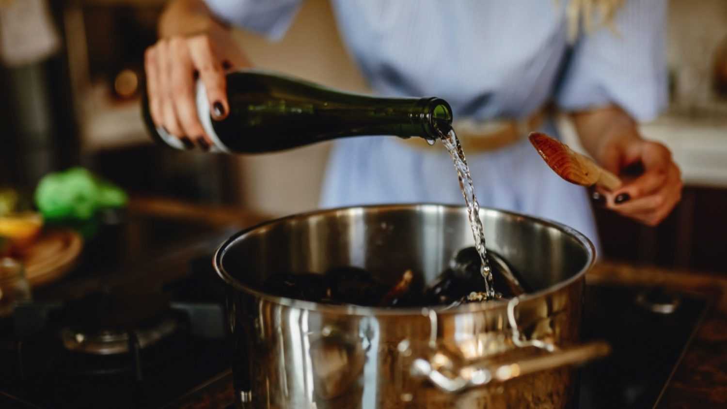 Girl adding wine to cooking
