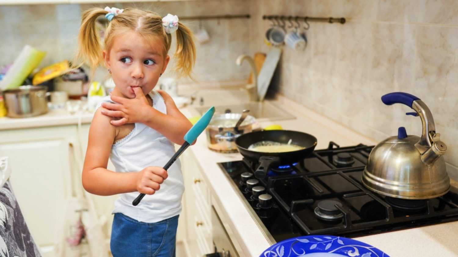 Kid making pancakes in kitchen