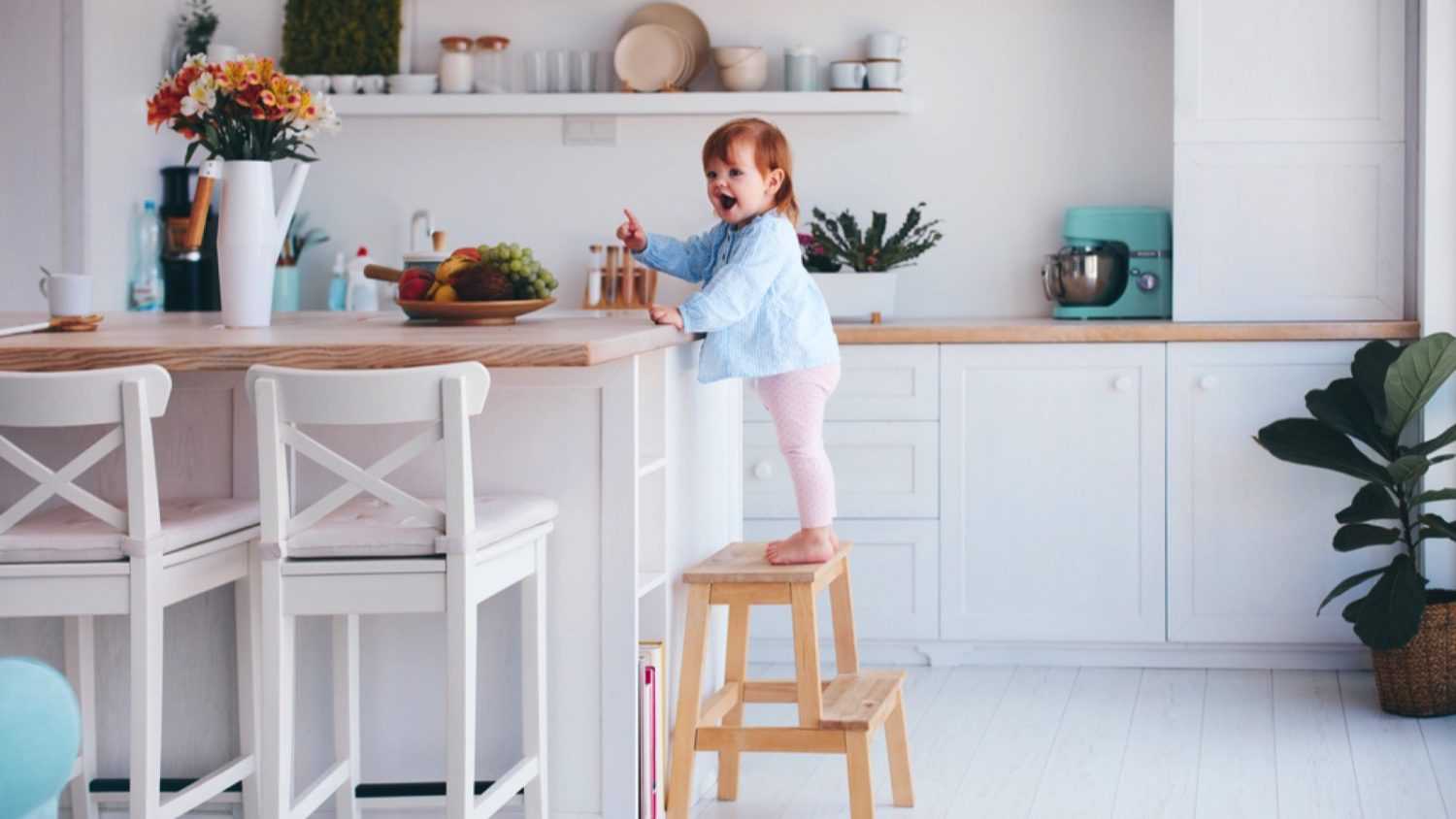 Kid using step stool in kitchen