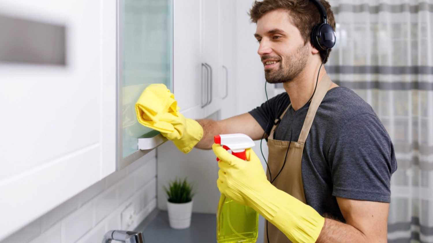 Man listening to music and dusting