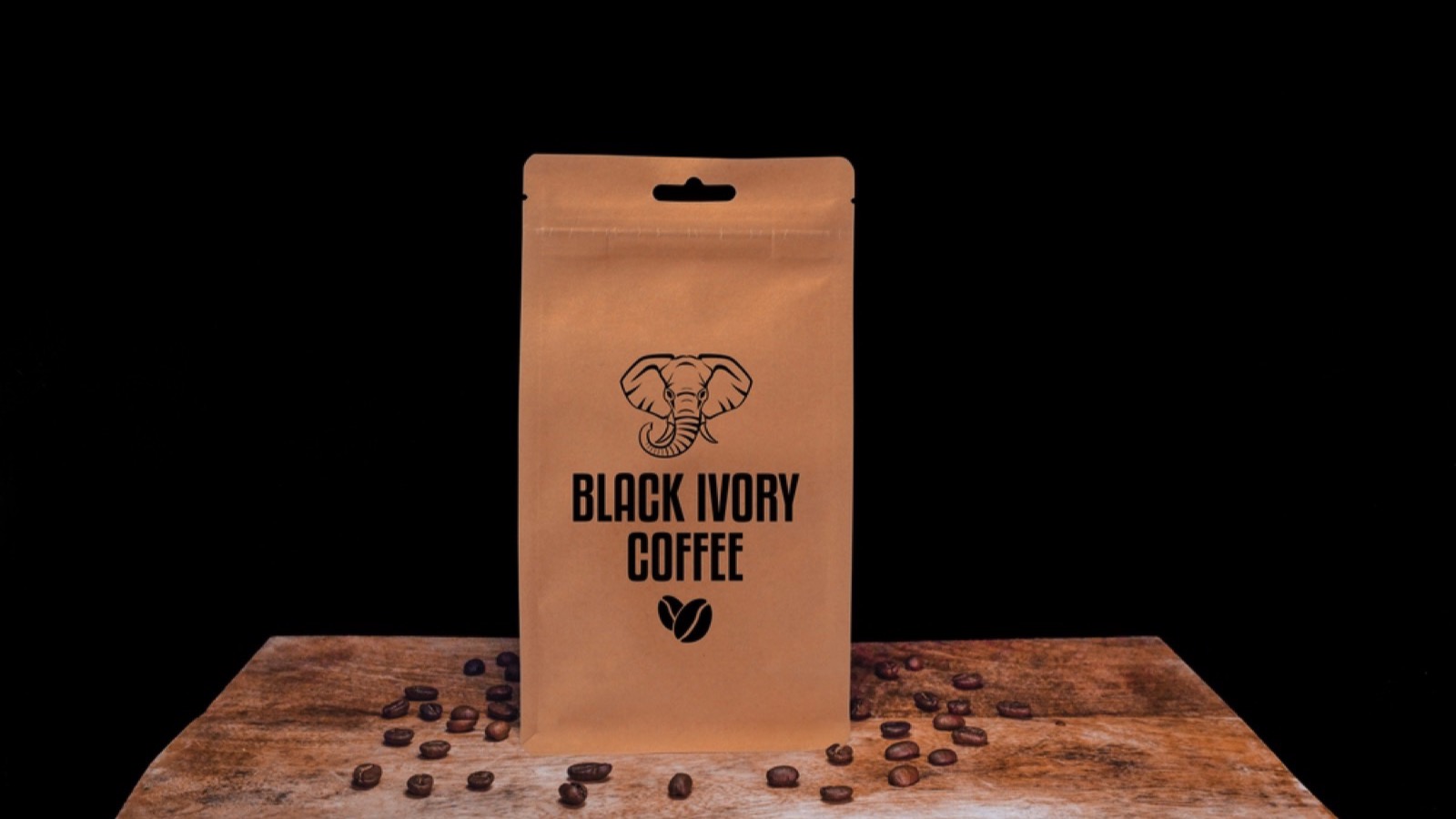 Black Ivory coffee beans and eco friendly kraft paper package on wooden board with black isolated background.