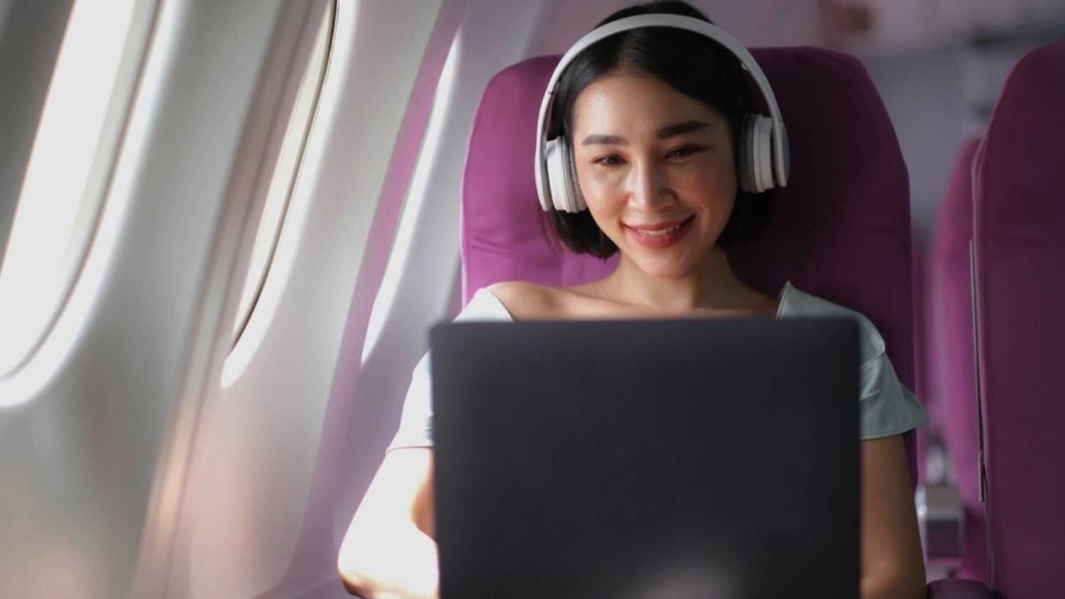 Woman in flight using laptop