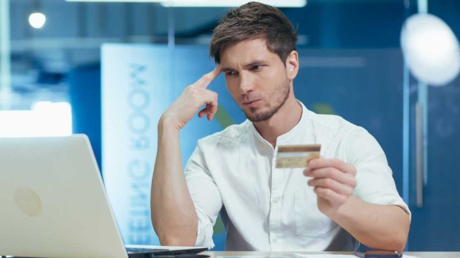 unhappy man using credit card