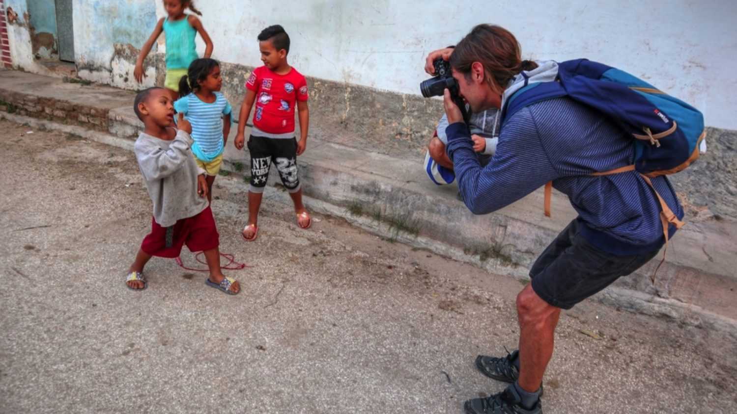 Traveler taking photo of poor kids