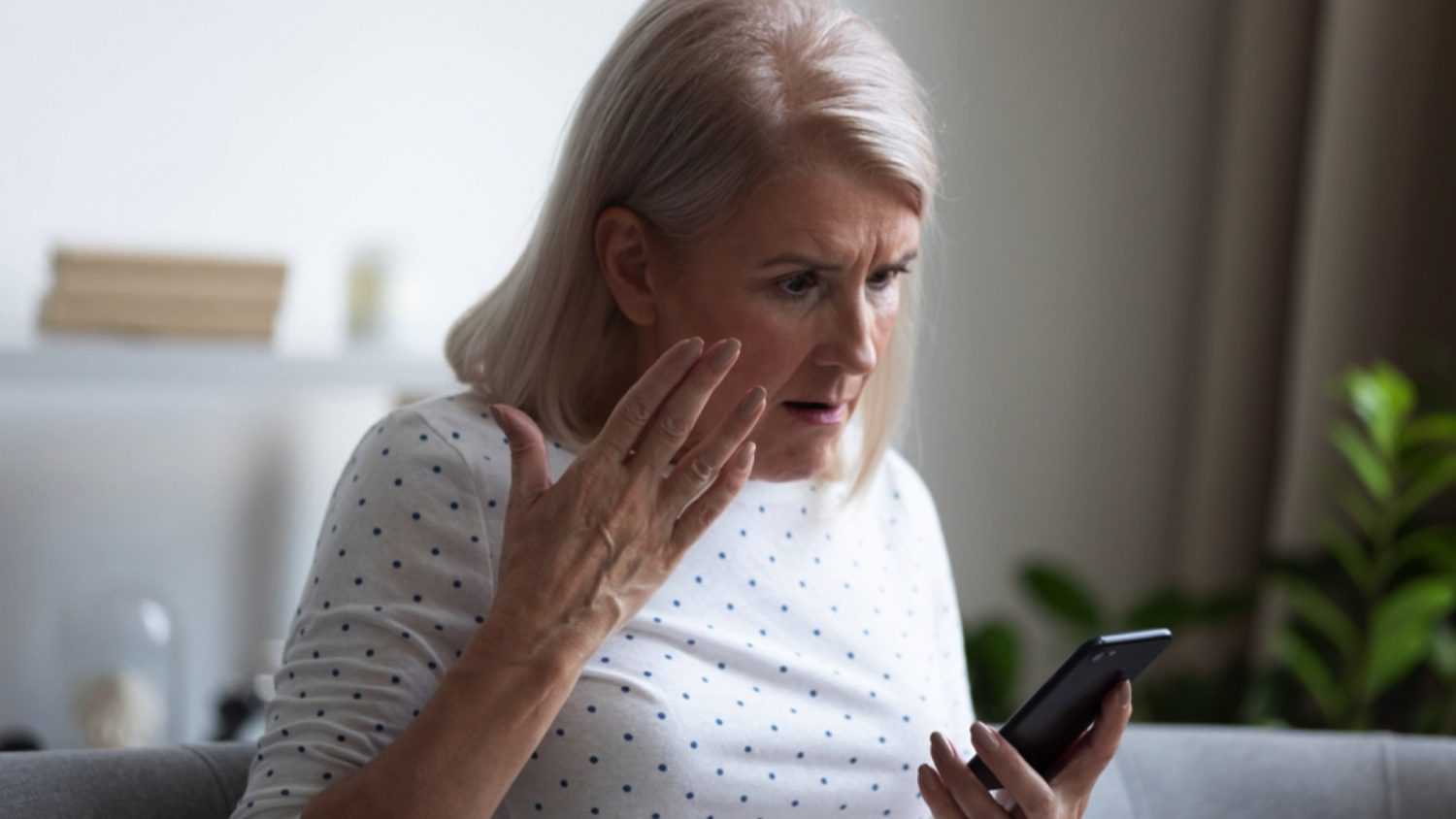 Upset and angry old woman seeing social media